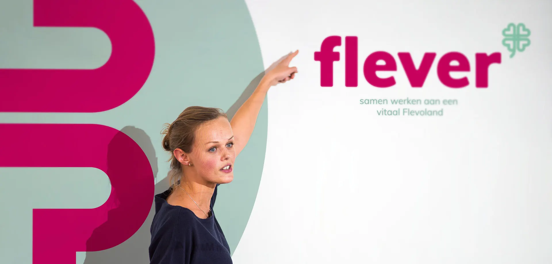 Vrouw wijst naar Flever logo